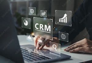 Person typing on laptop with holographic CRM interface showing business analytics and icons
