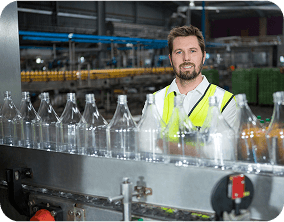 Food industry professional in safety gear working in automated food processing facility