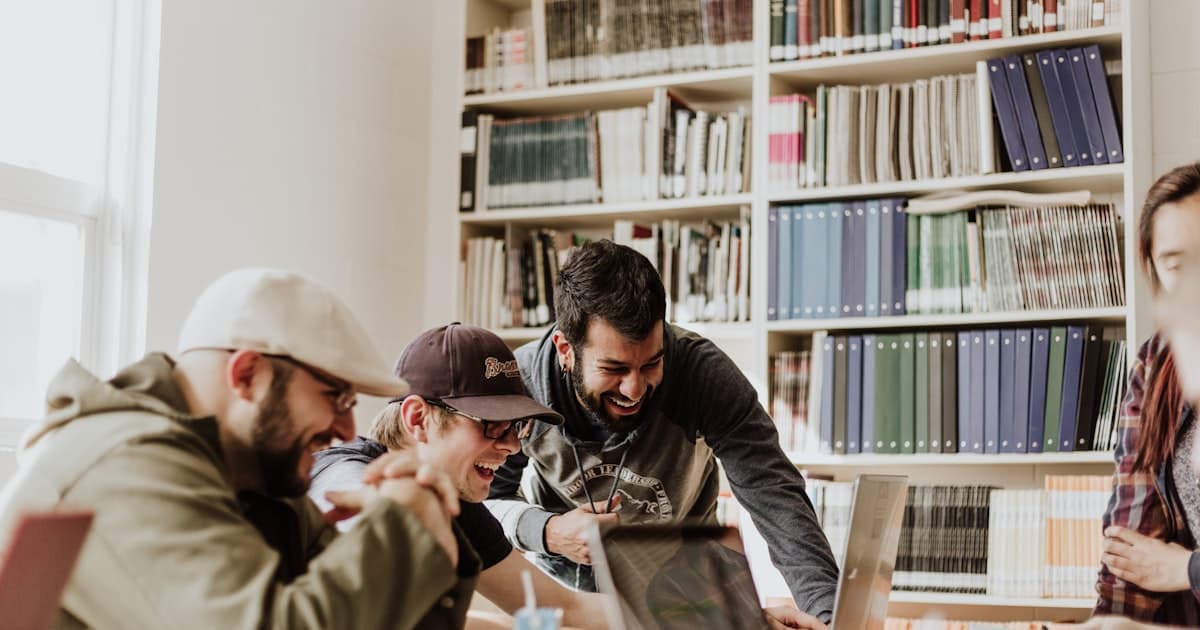 Students collaborating around a laptop in a university library