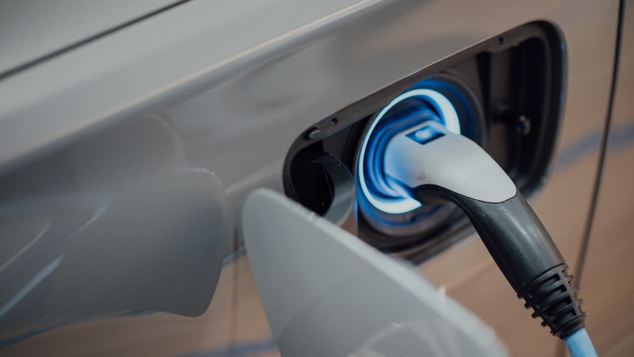Electric vehicle connected to bidirectional charger with smart grid AI optimization display
