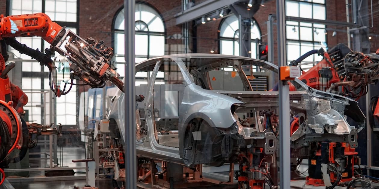 Indian manufacturing plant with AI-powered monitoring systems showing real-time machine dashboards