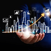 Hand holding a holographic city skyline with an upward trend arrow