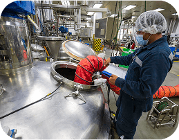 Food processing professional working with industrial equipment in modern facility