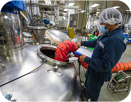 Food processing professional working with industrial equipment in modern facility
